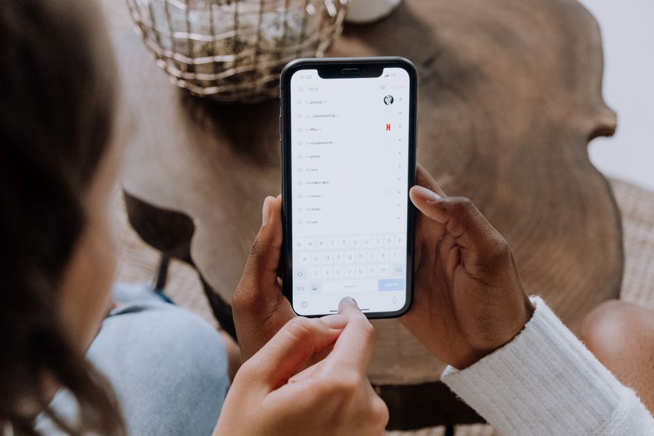 Person typing a question into a search bar on a phone