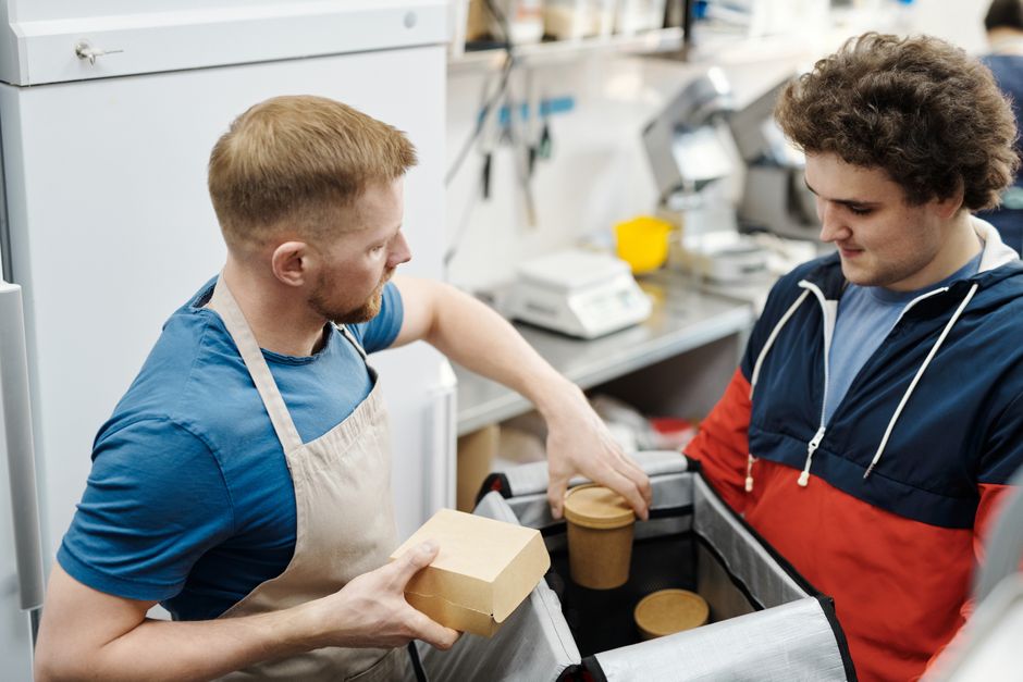Malaysian restaurant owner packing an online food order in the kitchen