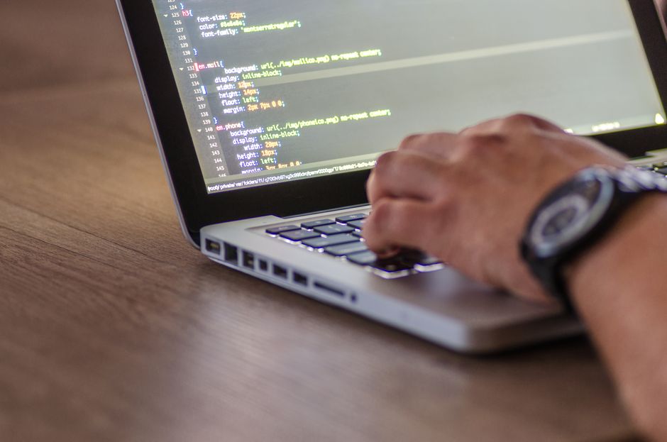 Web developer working on website code on a laptop
