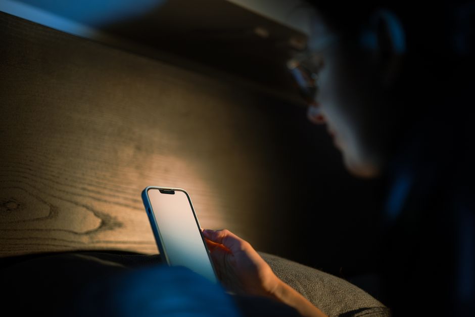 Person browsing property listings on a phone at night