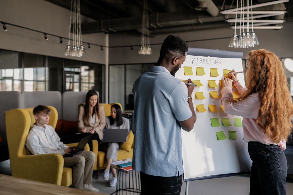 Brand strategy workshop discussion with sticky notes on a whiteboard