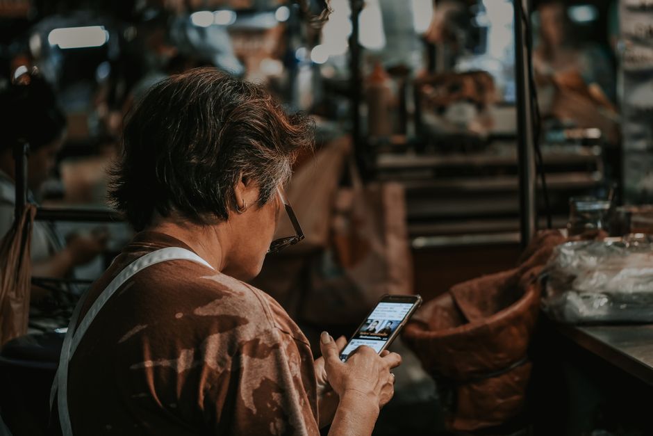 Malaysian shop owner checking Google Maps ranking on phone