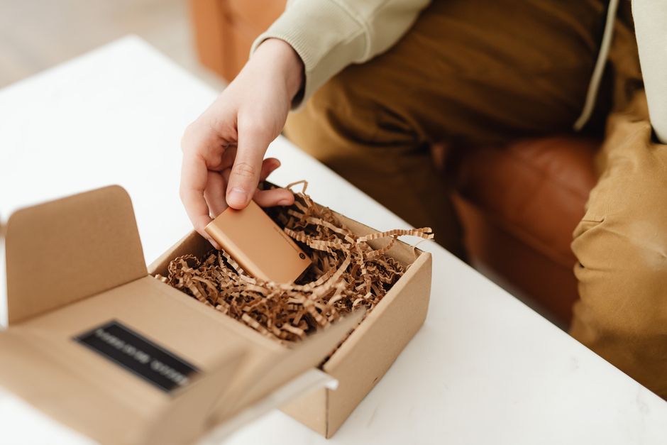 Hands unboxing a branded package with a personal insert