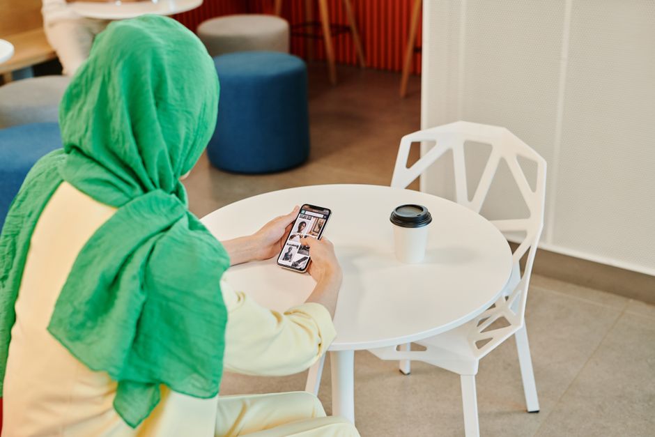 Person browsing a website on a phone in a casual cafe setting
