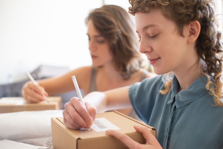 Home-based online seller packing parcel orders at a desk in Malaysia
