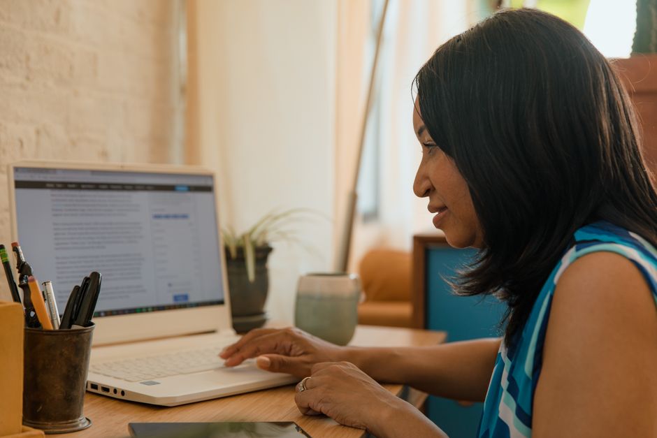 Malaysian business owner reviewing customer data on a laptop in the office